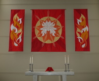 The three-part Pentecost quilt, in red with orange, yellow, and white flames.