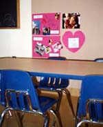 Room with child-sized table and chairs and student artwork on the walls.