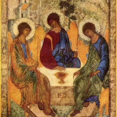 A painted icon of three seated figures, with halos, around a table.