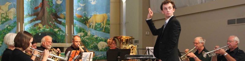 A young conductor leads the brass ensemble in the University Lutheran chancel.