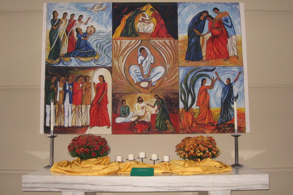 A colorful banner portraying seven small scenes of Biblical women hangs above the altar